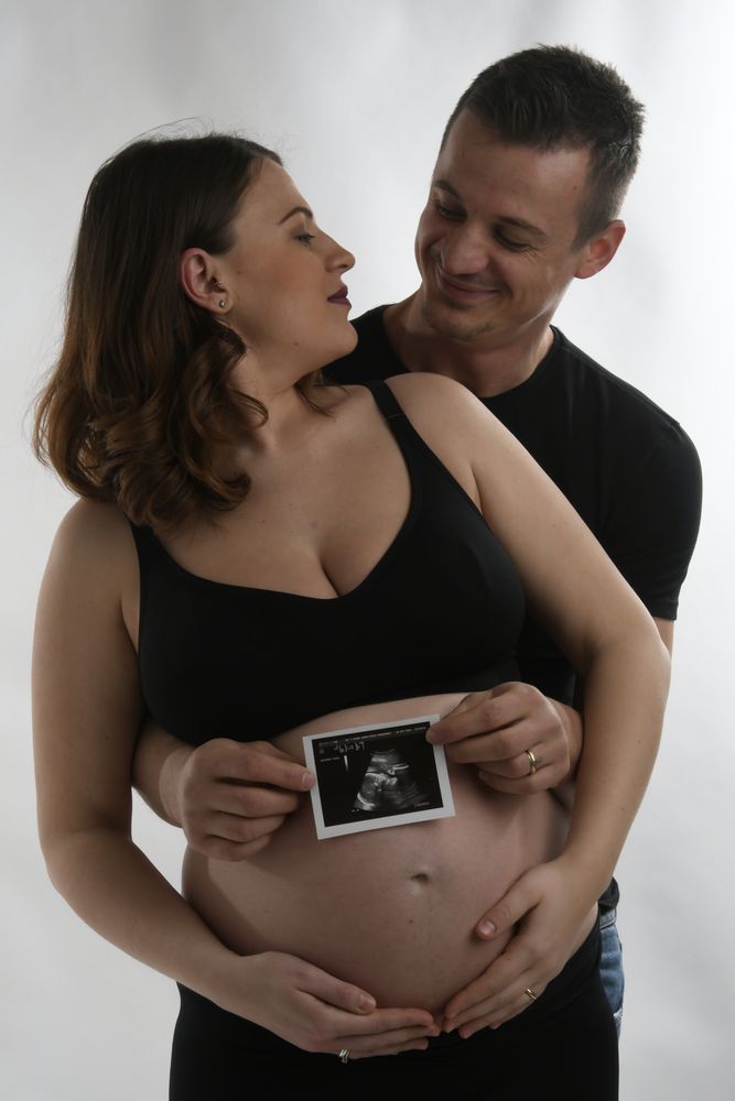 scatto maternità di servizio fotografico di coppia con immagine di ecografia